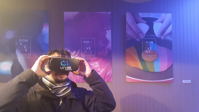 Un participant sous casque VR devant trois affiches de l'événement Mondial Events.